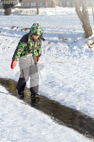 Image of Boy Sliding on Ice Rink