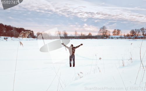 Image of Traveller With His Arms Raised Enjoys The Winter Landscape