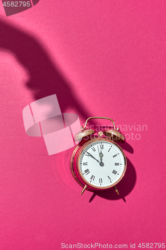 Image of Shadow\'s hand presses above alarmclock.