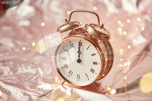 Image of Christmas card with golden alarmclock and garland.