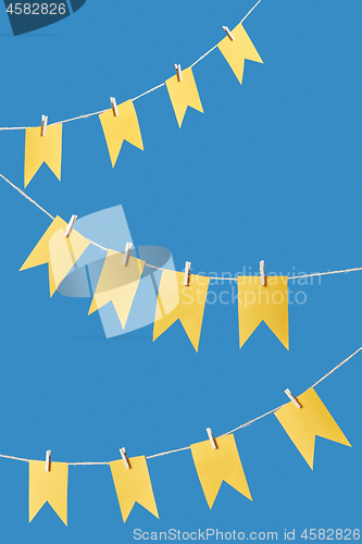 Image of Yellow flags garland on a rope.