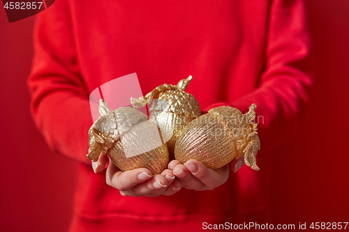 Image of Woman in red holds Christmas decoration.