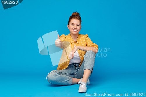 Image of happy red haired teenage girl showing thumbs up