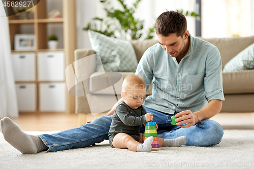 Image of father playing with little baby daughter at home