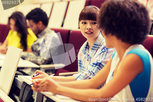 Image of group of students talking in lecture hall