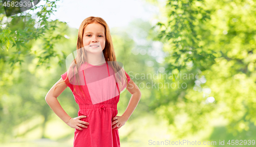 Image of smiling red haired girl posing in pink dress