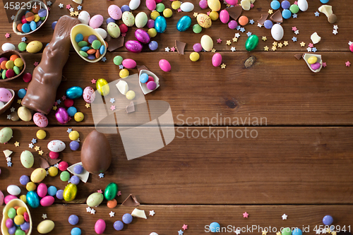 Image of chocolate eggs, easter bunny and candies on wood