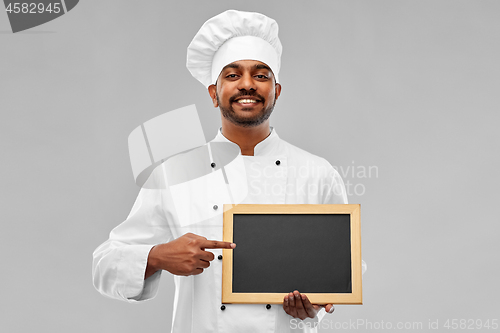 Image of happy male indian chef in toque with chalkboard