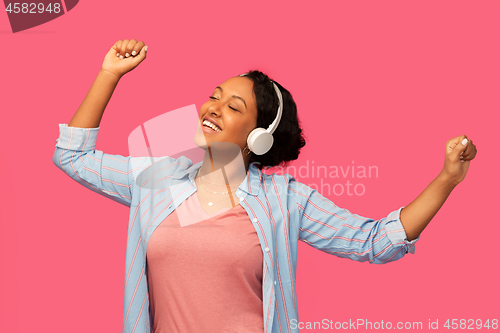 Image of african woman in headphones listening to music