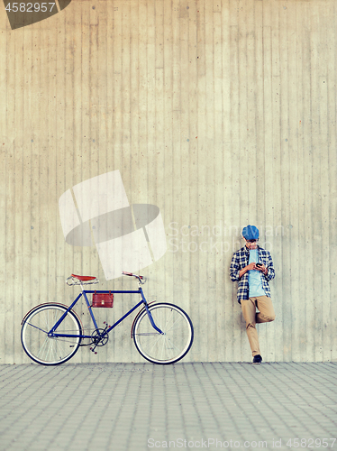 Image of man with smartphone, earphones and bicycle