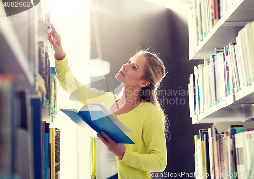 Image of high school student girl reading book at library