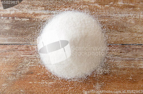 Image of close up of white sugar heap on wooden table