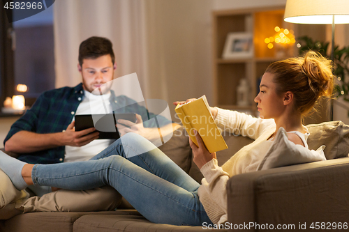 Image of couple with tablet computer and book at home