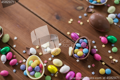 Image of chocolate eggs and candy drops on wooden table