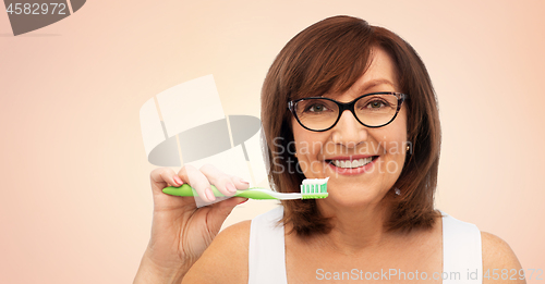 Image of senior woman with toothbrush brushing her teeth