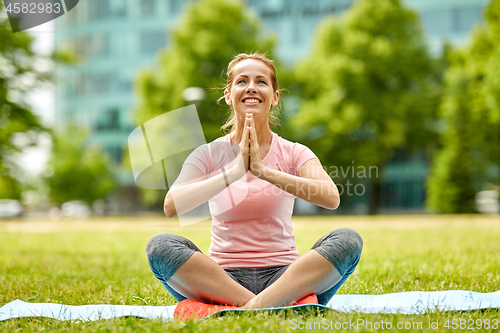 Image of happy woman meditating in summer park