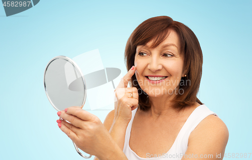 Image of portrait of smiling senior woman with mirror