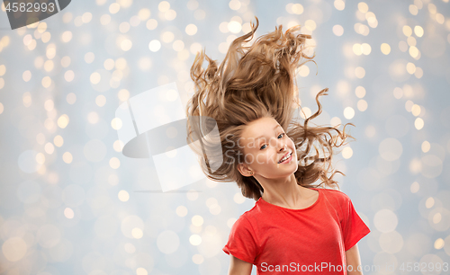 Image of smiling teenage girl in red with long wavy hair