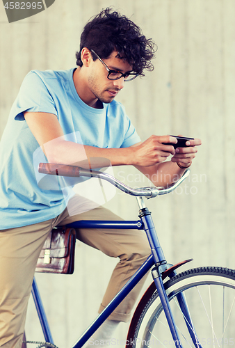 Image of man with smartphone and fixed gear bike on street