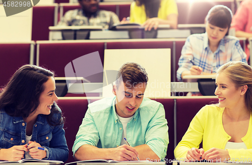 Image of group of students with notebooks in lecture hall