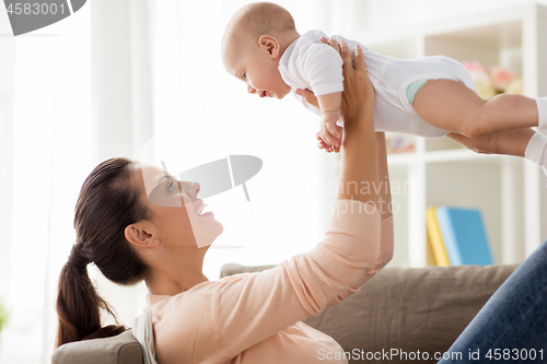 Image of happy mother playing with little baby boy at home