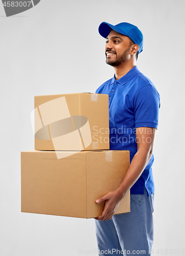 Image of happy indian delivery man with parcel boxes