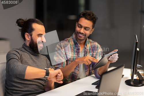 Image of creative team with tablet pc works at night office