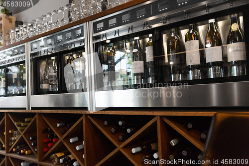 Image of close up of wine bottles in dispenser at bar