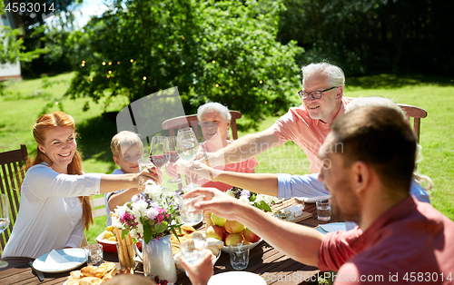 Image of happy family having dinner or summer garden party