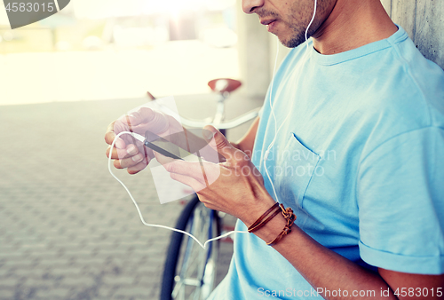 Image of man with earphones and smartphone listening music