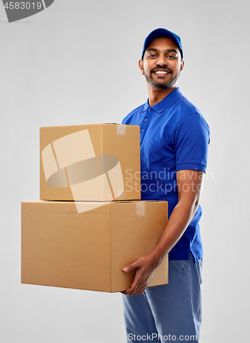 Image of happy indian delivery man with parcel boxes