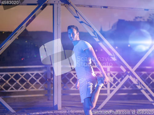 Image of man jogging across the bridge in the city