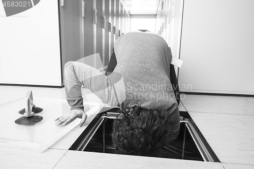 Image of engineer connecting cables in server room