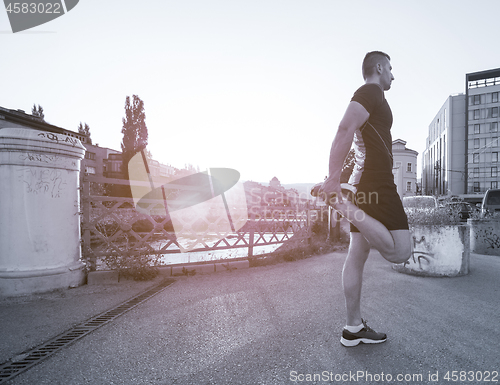 Image of athlete man warming up and stretching