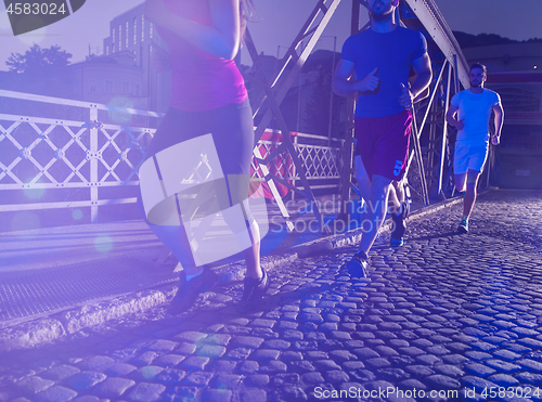 Image of young people jogging across the bridge