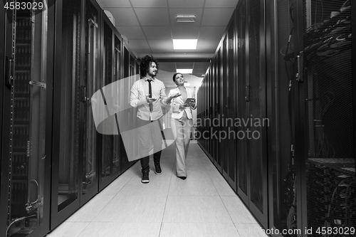 Image of engineer showing working data center server room to female chief