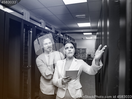 Image of engineer showing working data center server room to female chief