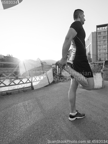 Image of athlete man warming up and stretching