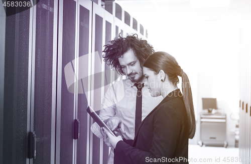 Image of engineer showing working data center server room to female chief