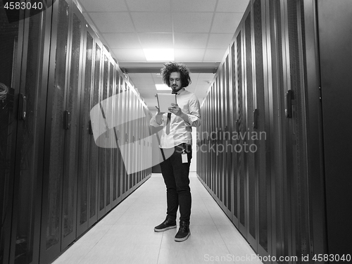 Image of IT engineer working on a tablet computer in server room