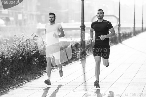 Image of group of young people jogging in the city