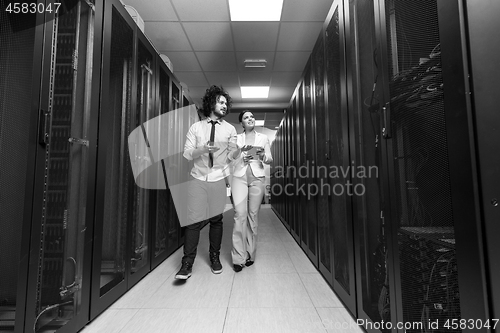 Image of engineer showing working data center server room to female chief