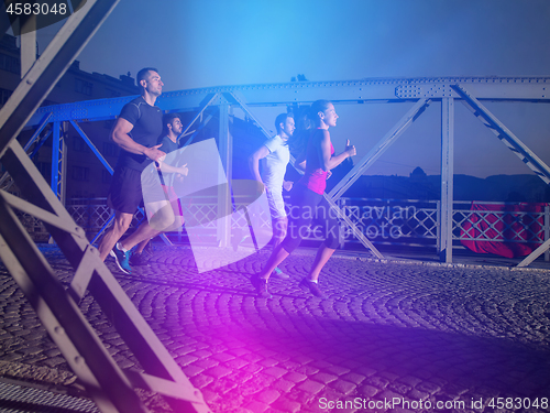 Image of young people jogging across the bridge