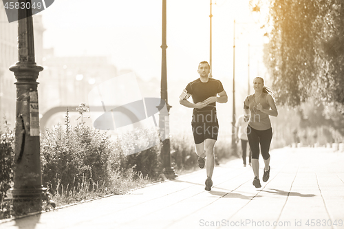 Image of young couple jogging  in the city