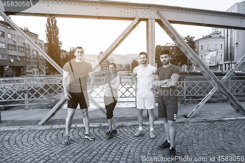 Image of group of young people jogging across the bridge