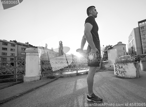 Image of athlete man warming up and stretching