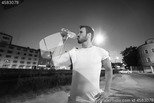 Image of man drinking water after running session