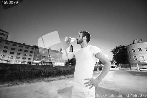 Image of man drinking water after running session