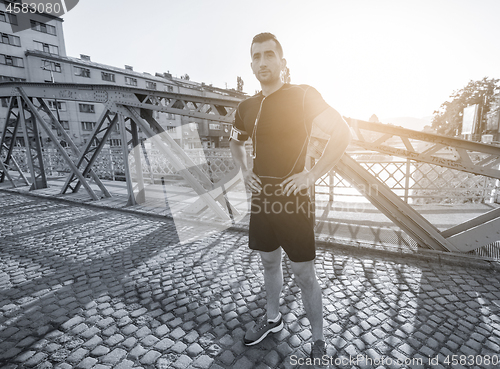 Image of portrait of a jogging man at sunny morning