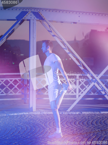 Image of man jogging across the bridge in the city